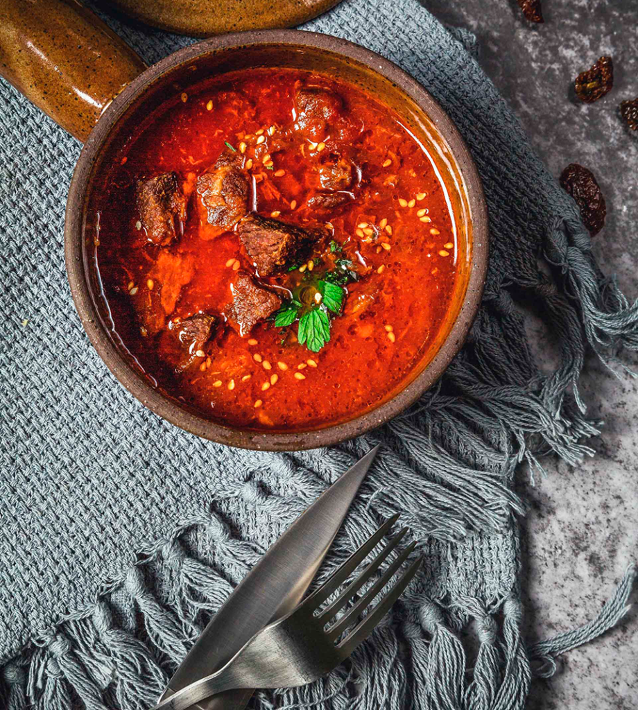 A photo of a rustic bowl, with a meaty soup.