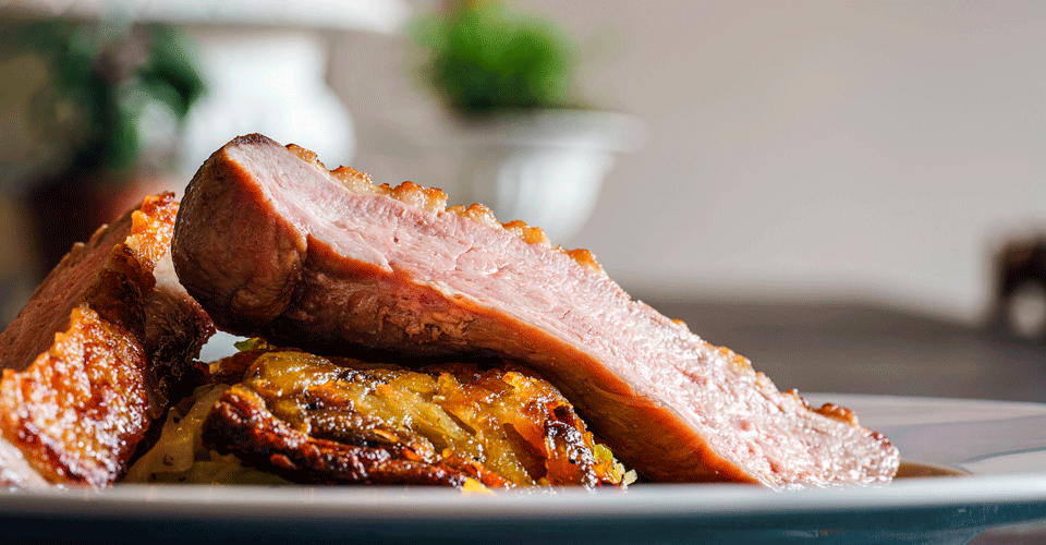 An image of a plate with slices of duck.